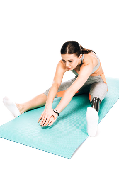 overhead view of disabled sportswoman stretching on fitness mat isolated on white - Фото, зображення