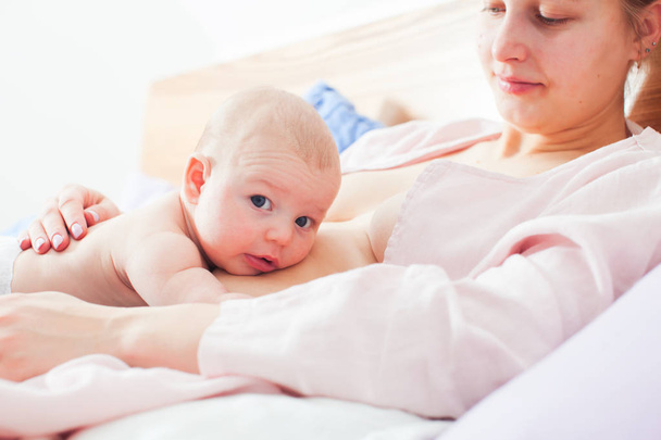 Recién nacido y madre en pose relajada y relajada de lactancia materna
 - Foto, Imagen