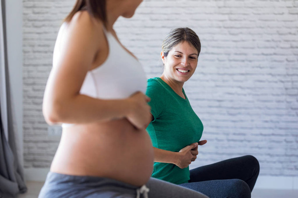 Beautiful pregnant woman with her physiotherapist doing pilates exercises preparing for childbirth. - Fotografie, Obrázek