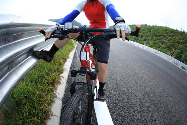Donna ciclista in sella Mountain Bike in autostrada
 - Foto, immagini