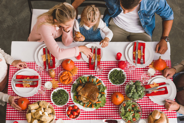 vista superior de los miembros de la familia sentados en la mesa en el día de Acción de Gracias
      - Foto, Imagen
