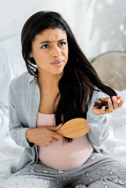 сердитая беременная американка в пижаме с расчёской в квартире
  - Фото, изображение