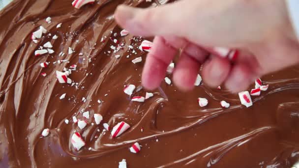 Женщина делает шоколадную кору, увенчанную кусочками мятной конфеты
 - Кадры, видео