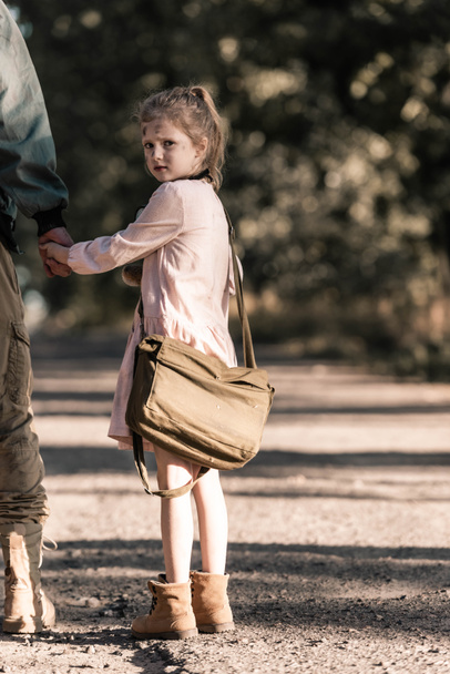 cropped view of man holding hands with cute kid, post apocalyptic concept - Fotografie, Obrázek