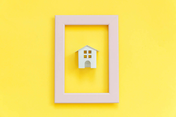 Semplicemente design con miniatura casa giocattolo bianco in cornice rosa isolato su sfondo giallo alla moda colorato
 - Foto, immagini