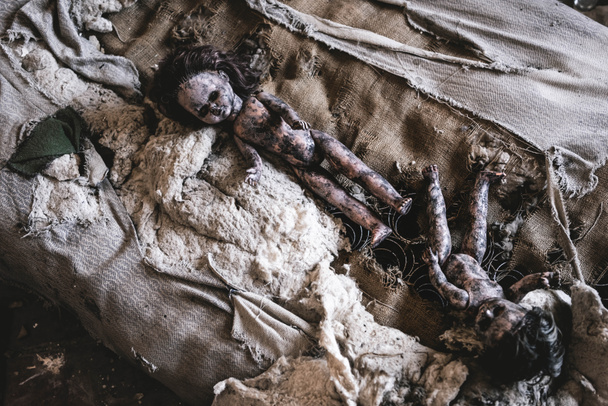 top view of scary and burnt baby dolls on damaged bed, post apocalyptic concept - Foto, Imagen