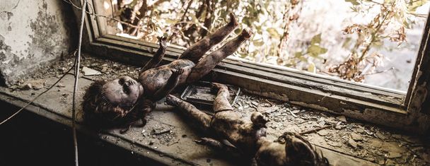 panoramic shot of scary and burnt baby dolls near window, post apocalyptic concept - Foto, afbeelding