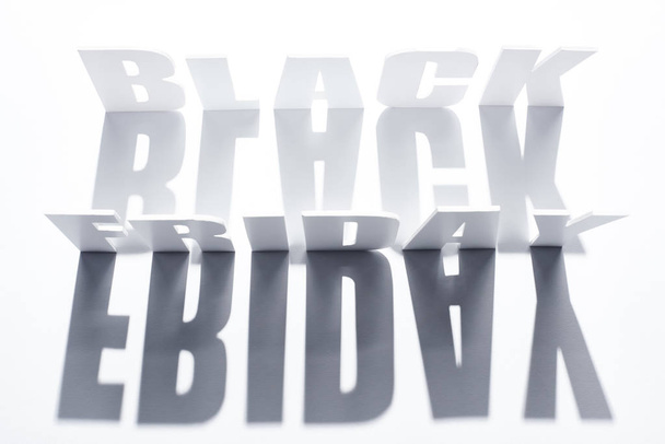 top view of black Friday lettering with shadow on white background - Фото, изображение