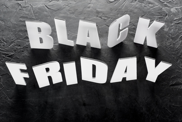 top view of black Friday lettering on black background - Foto, imagen