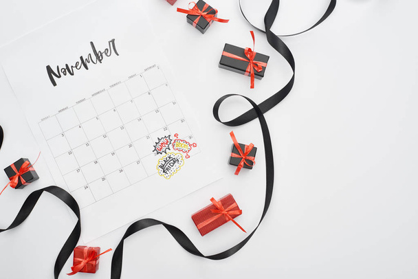 верхний вид календаря с 29 ноября отмечена дата на белом фоне с черной лентой и подарки
 - Фото, изображение