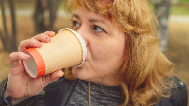 Adult woman drinking coffee in the autumn Park - Foto, Imagem