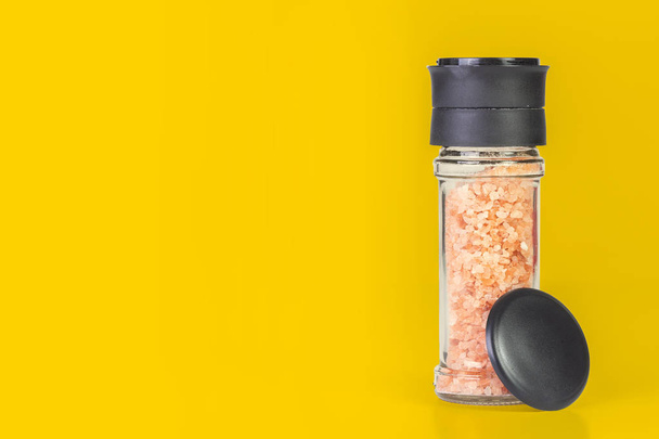 Himalayan salt crystals in a glass grinder on white background - Photo, Image