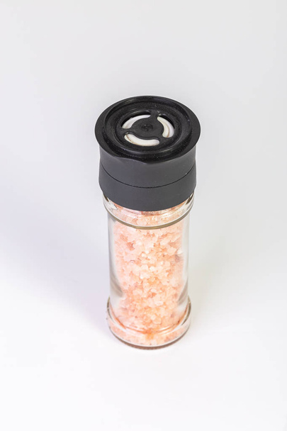 Himalayan salt crystals in a glass grinder on white background - Photo, Image