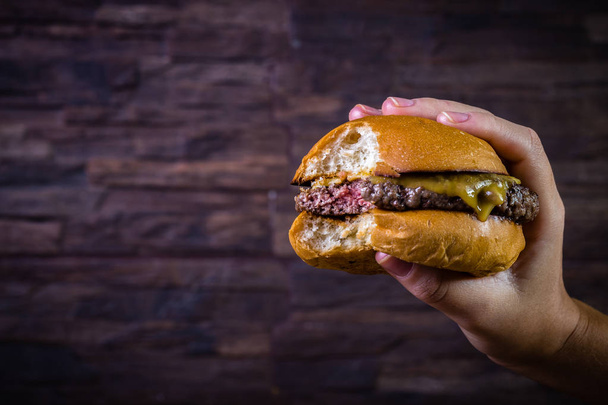 Hand holding a craft beef burger  - Foto, immagini