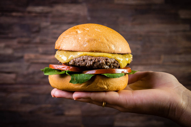 Hand holding a craft beef burger  - Φωτογραφία, εικόνα