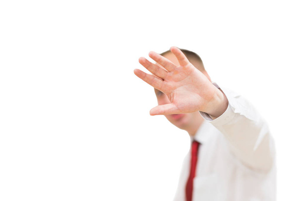 Shocked and terrified man forbids taking pictures of himself. Portrait of young man in shirt and red tie covering his face by hand and looking at camera isolated on white background - Photo, Image