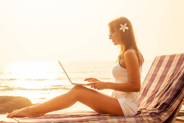 Vrouw freelance freelancer met laptop op het strand zittend in zomercafé. Business Lady Remote werk surfer surfen online browser - Foto, afbeelding