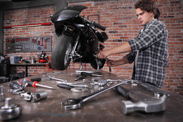 Сделайте это сами, молодой человек ремонт мотоцикла в гараже W
 - Фото, изображение
