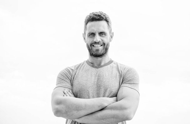muscular male with beard. happy man isolated on white. sportsman with athletic body. coach in fitness gym. after workout. man athlete in blue sport tshirt. sportswear fashion. happy smiling man - Foto, imagen