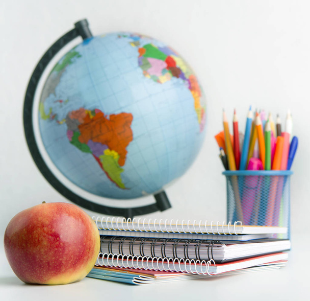 Close up of world globe and school stationery on white - Foto, Imagem