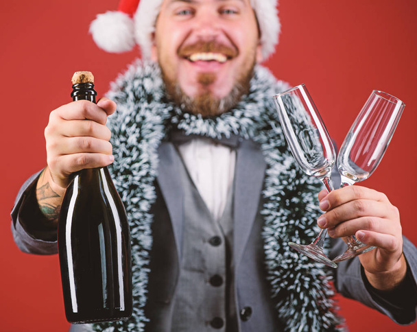Corporate christmas party. Lets drink champagne. Boss santa hat tinsel celebrate new year or christmas. Christmas party invitation. Join christmas celebration. Man bearded hipster santa hold bottle - Foto, imagen