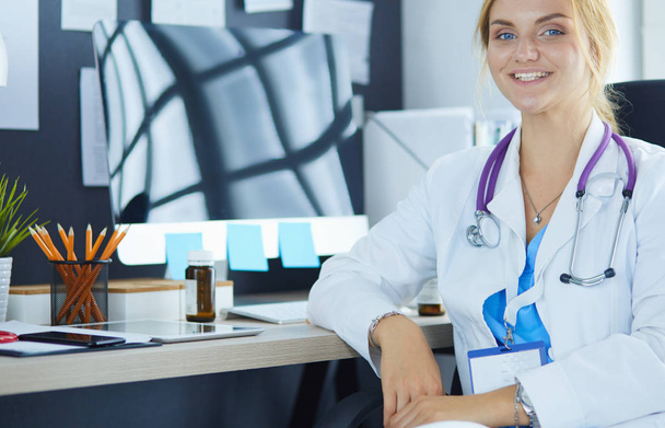 Muotokuva nuori nainen lääkäri istuu pöydän ääressä sairaalassa - Valokuva, kuva