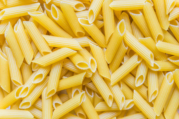 Kleurrijke voedsel achtergrond van penne rigate pasta. - Foto, afbeelding