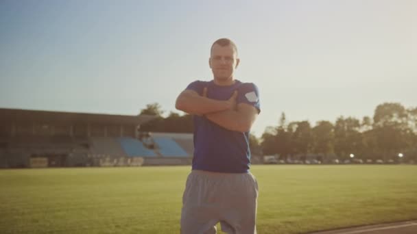 Athletic Disabled Fit Man with Prosthetic Running Blades is Posing with Crossed Arms on an Outdoor Stadium on a Sunny Afternoon. Amputee Runner Standing on a Track. Motivational Sports Footage. - Materiał filmowy, wideo