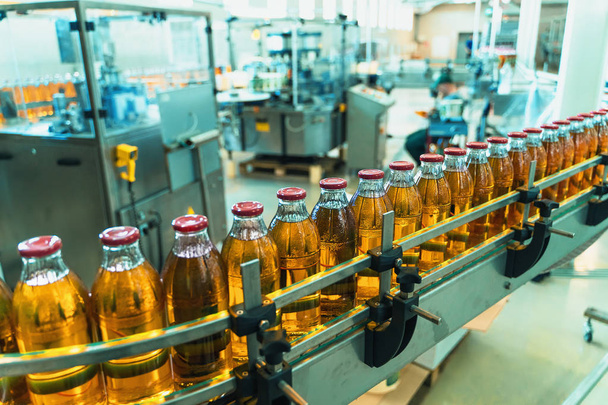 Конвеєрний пояс, сік у пляшках на напоях заводу чи заводу в синьому кольорі, виробнича лінія
 - Фото, зображення