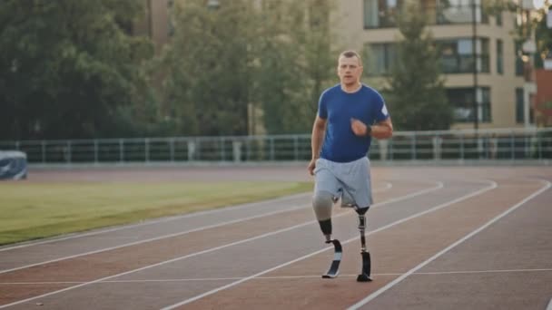 Athletic Disabled Fit Man with Prosthetic Running Blades is Training on a Outdoors Stadium on a Sunny Afternoon. Amputee Runner Jogging on a Stadium Track. Motivational Sports Footage. - Filmagem, Vídeo