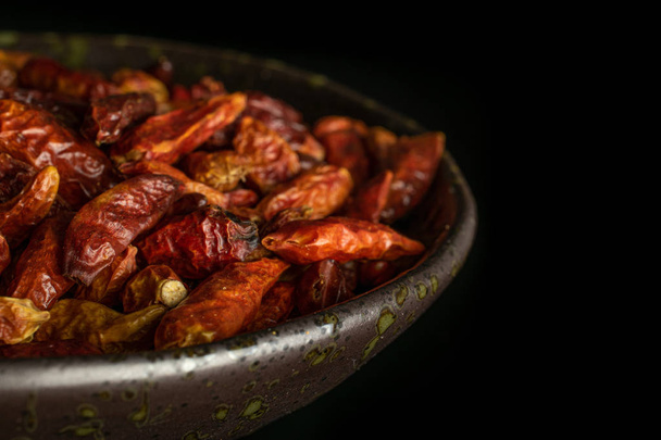 Dry red pepperoncino pepper isolated on black glass - 写真・画像