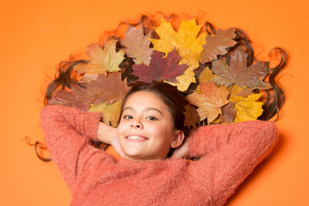 Little girl small child gorgeous long hair and fallen maple leaves. Moisturizing mask. Deep conditioning treatment to combat static and tangles that come with fall. Haircare tips add to fall routine - Fotoğraf, Görsel