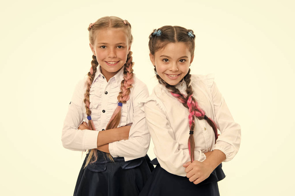 Sisters little girls with braids ready for school. School fashion concept. Be bright. School friendship. Sisterhood relationship and soulmates. On same wave. Schoolgirls wear formal school uniform - 写真・画像
