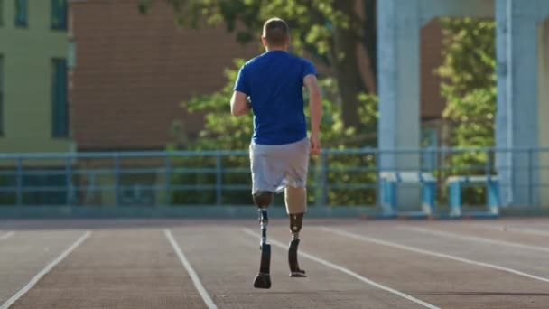 Athletic Disabled Fit Man with Prosthetic Running Blades is Training on a Outdoors Stadium on a Sunny Afternoon. Amputee Runner Jogging on a Stadium Track. Motivational Sports Footage. - Séquence, vidéo