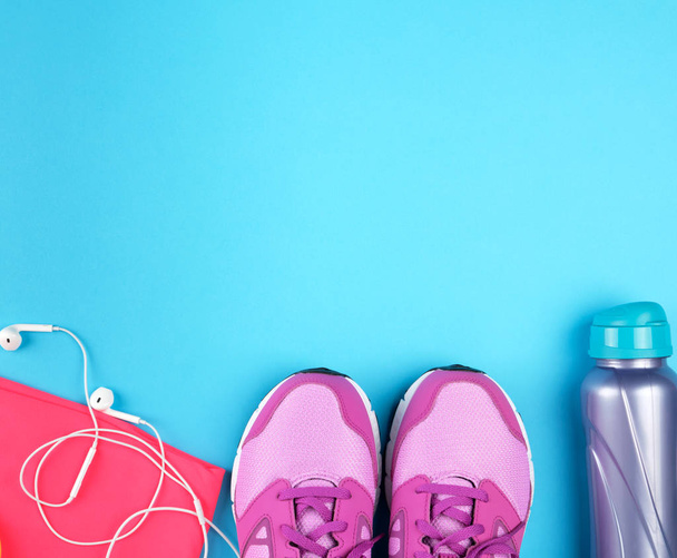 par de zapatillas de deporte de color rosa con cordones sobre un fondo azul, vista superior
, - Foto, imagen