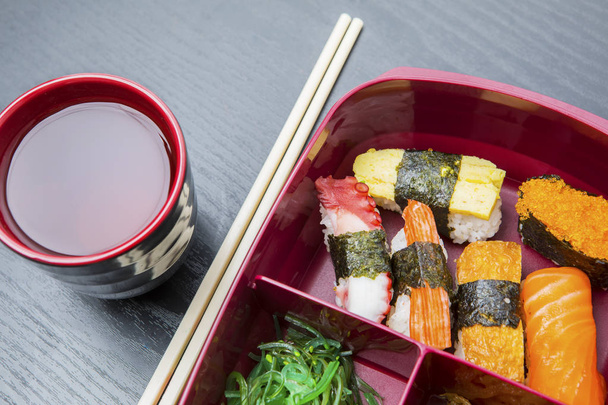 Lunch box served with soy sauce and chopsticks - Foto, afbeelding