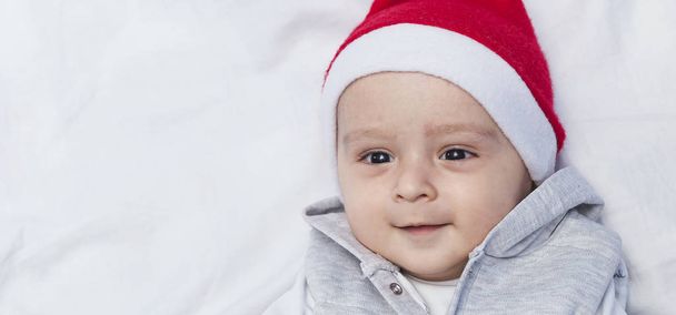 Petit Père Noël. Bébé garçon de 1 an en bonnet de Père Noël. Enfants de Noël
 - Photo, image