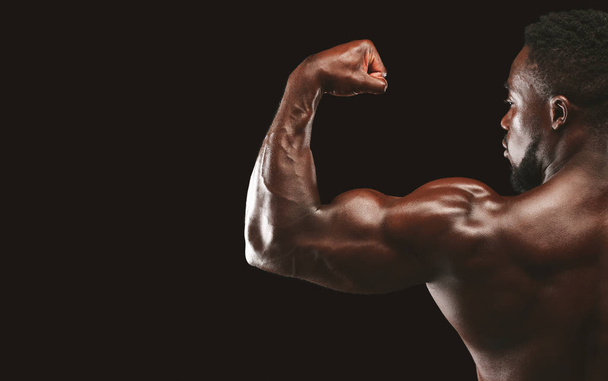Silné biceps z afro sportovce na černém pozadí - Fotografie, Obrázek