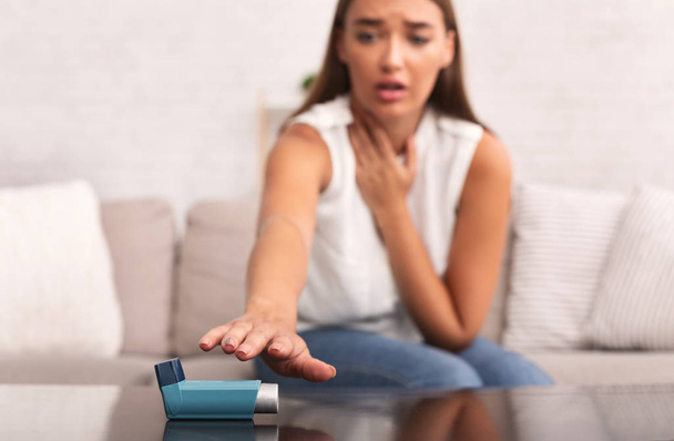 Mädchen greift nach Asthma-Inhalator, um zu Hause Depressionen der Atemwege zu verhindern - Foto, Bild