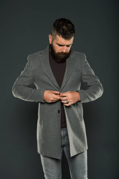 Dressing as fashionable man. Fashionable look of vogue model on grey background. Bearded man buttoning fashionable jacket. Fashionable hipster wear casual style - Fotografie, Obrázek
