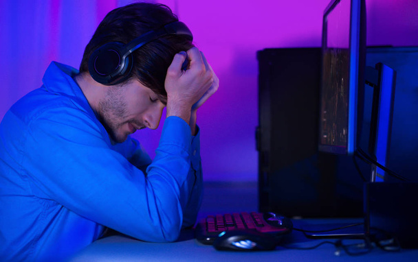 Loss control. Upset gamer in headphones expressing disappointment - Valokuva, kuva