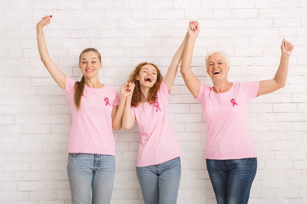 Duvara Karşı El Ele Meme Kanseri Tişörtleri Giyen Üç Kadın - Fotoğraf, Görsel