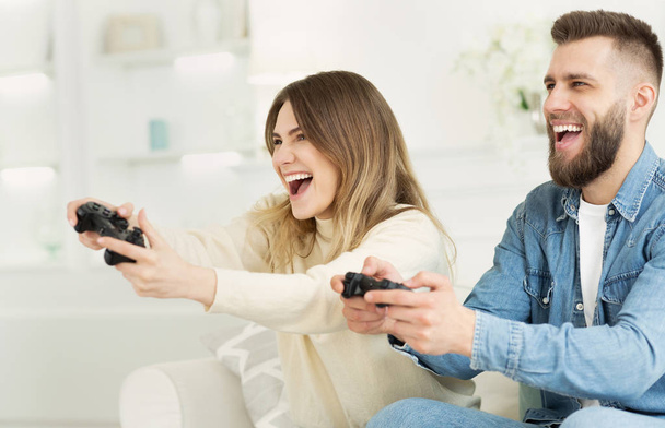 Couple joyeux jouer à des jeux vidéo en ligne par joysticks
 - Photo, image
