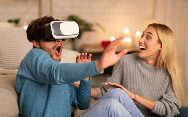 Couple excité utilisant casque de réalité virtuelle à la maison
 - Photo, image