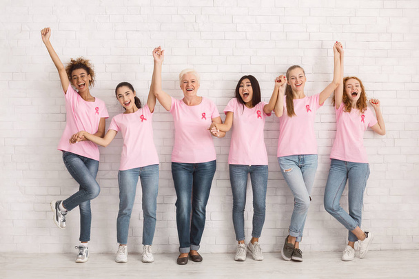 Diverse Ladies In Breast Cancer T-Shirts Celebrating Success Indoor - Foto, afbeelding