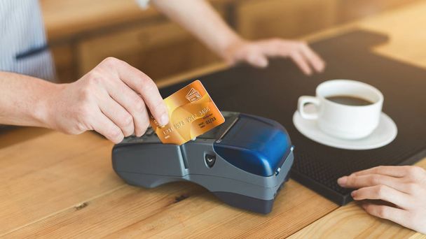Close up of man paying with credit card in cafe for coffee - Photo, Image