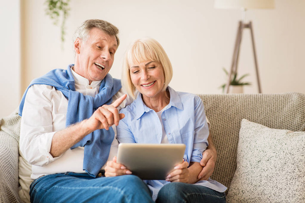 Aufgeregtes Senioren-Paar telefoniert per Tablet - Foto, Bild