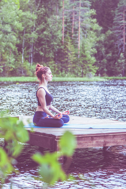 Meditazione yoga da Giovane ragazza yogi sul molo di una bella
 - Foto, immagini