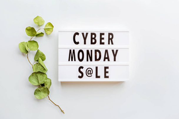 Creative promotion composition Cyber monday sale text on lightbox, eucalyptus branch on white background. Flat lay, top view, overhead, mockup, copy space, template - Fotó, kép