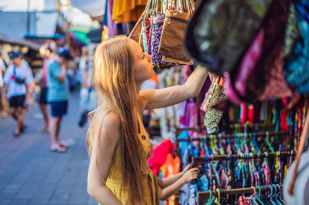 Woman traveler choose souvenirs in the market at Ubud in Bali, Indonesia - Фото, зображення